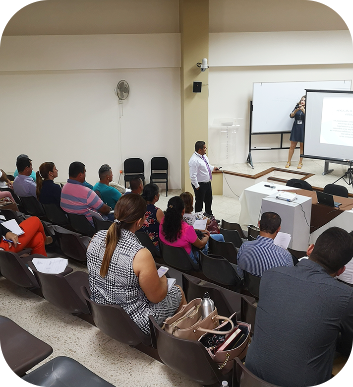 varias personas sentadas observando a un señor exponer