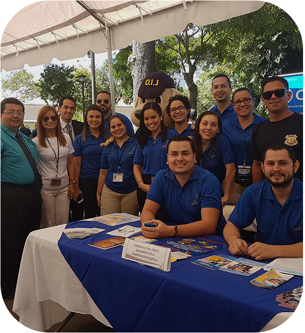varias personas posando para una fotografía, hay una mesa con información