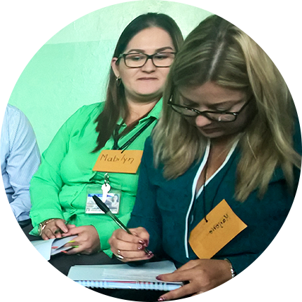 dos mujeres sentadas, escribiendo en sus cuadernos