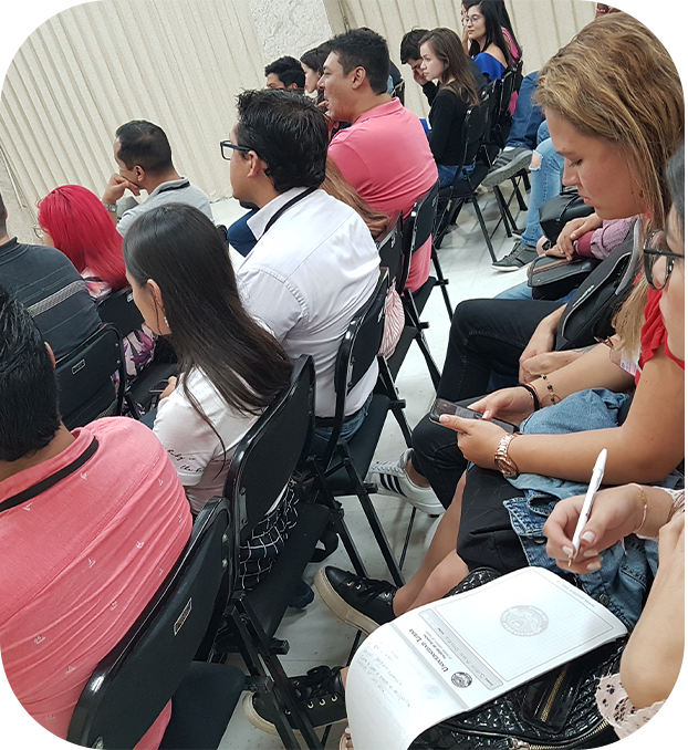 mujeres y hombres recibiendo una capacitación, hay una mujer tomando notas.