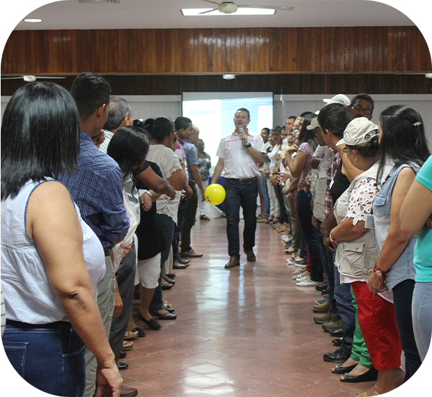 hombre va caminando con un micrófono en la mano, a los lados hay varias personas observándolo.