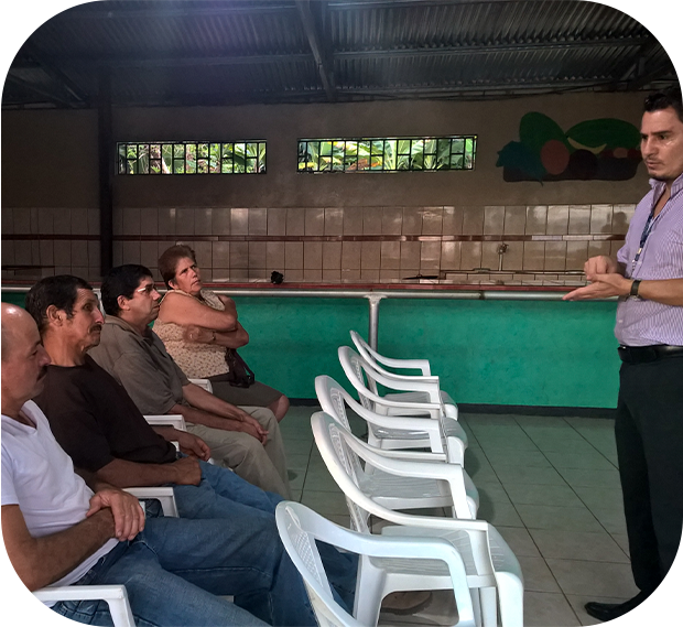 un hombre dando una charla a varias personas que están sentadas poniendo atención.